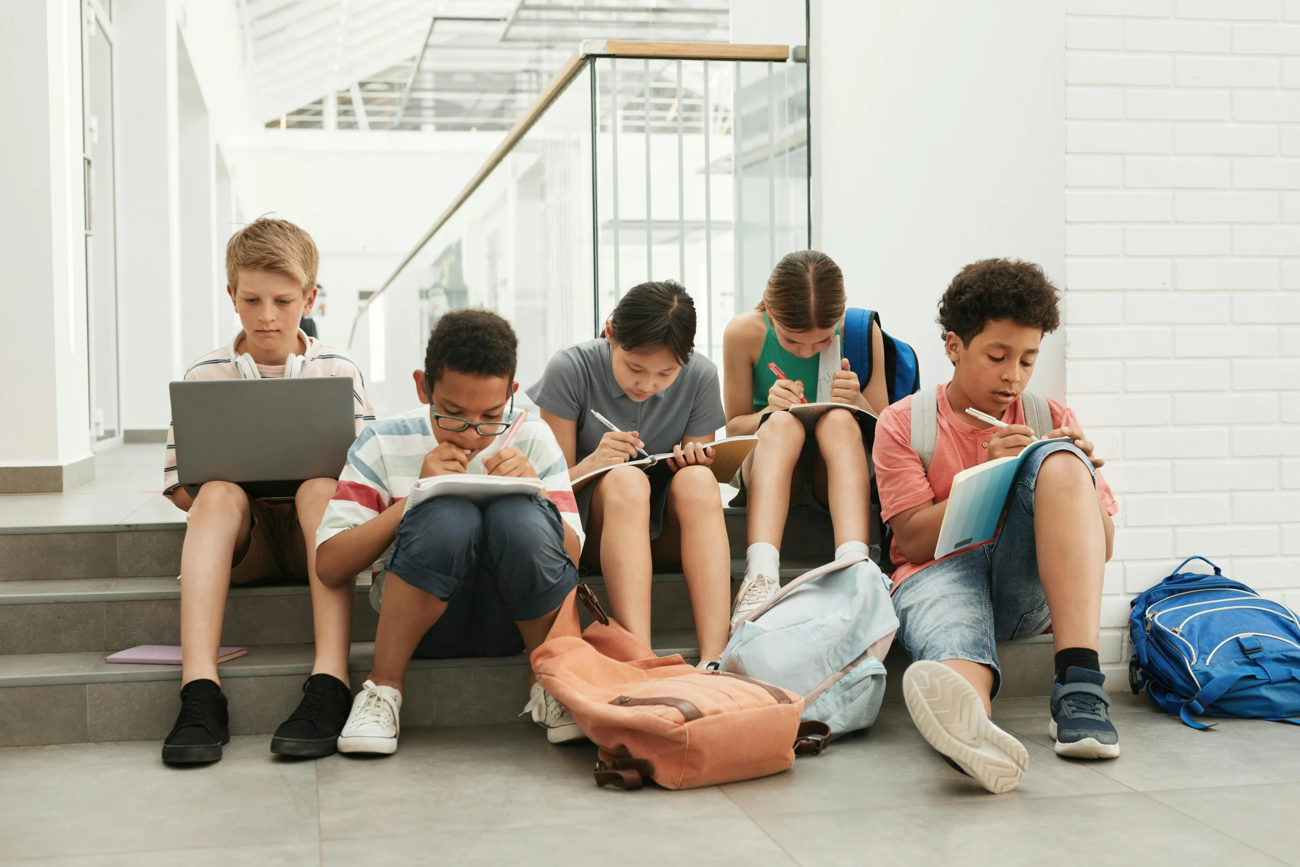 a group of kids studying together in a hallway.