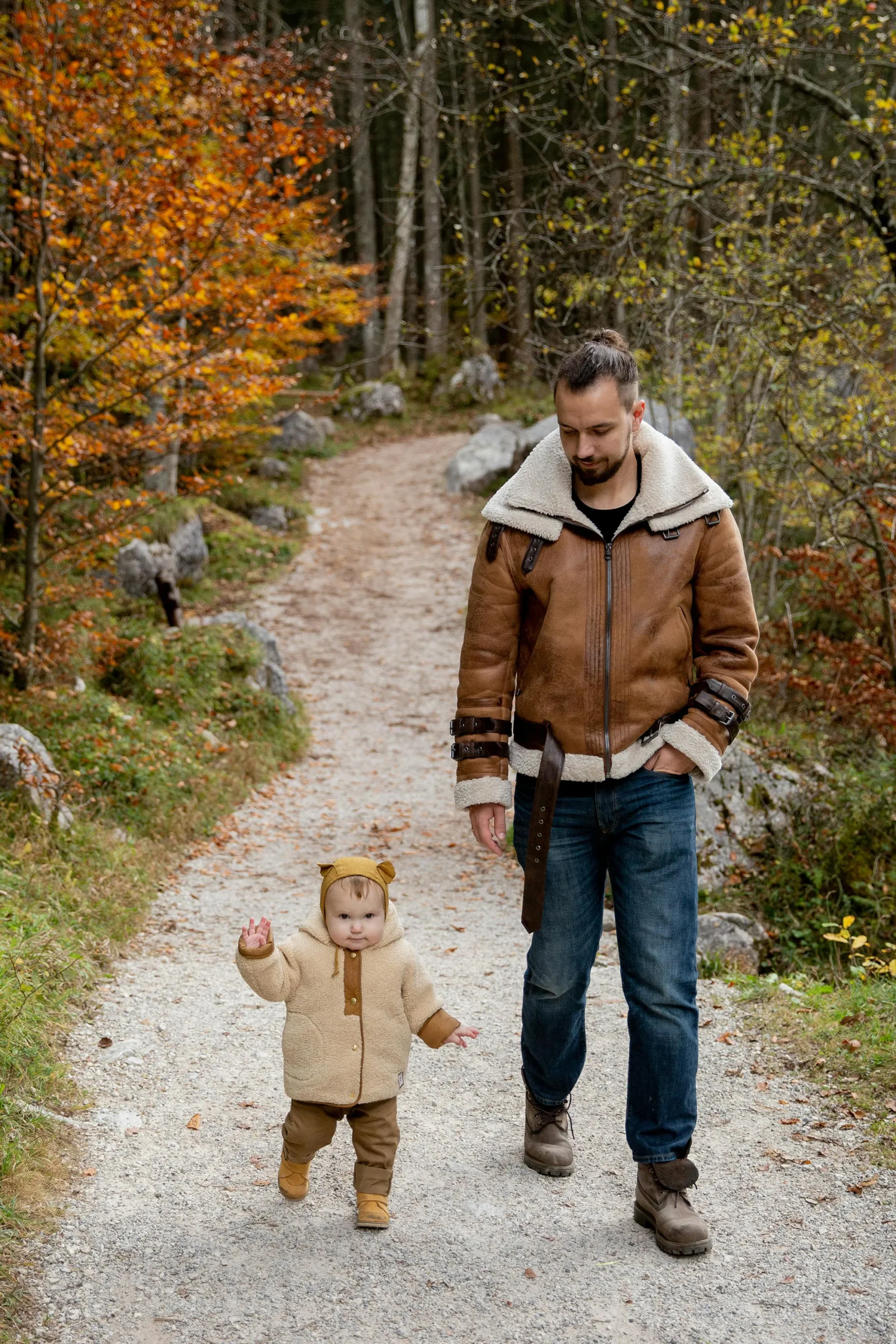 a parent and child walking on a trail.