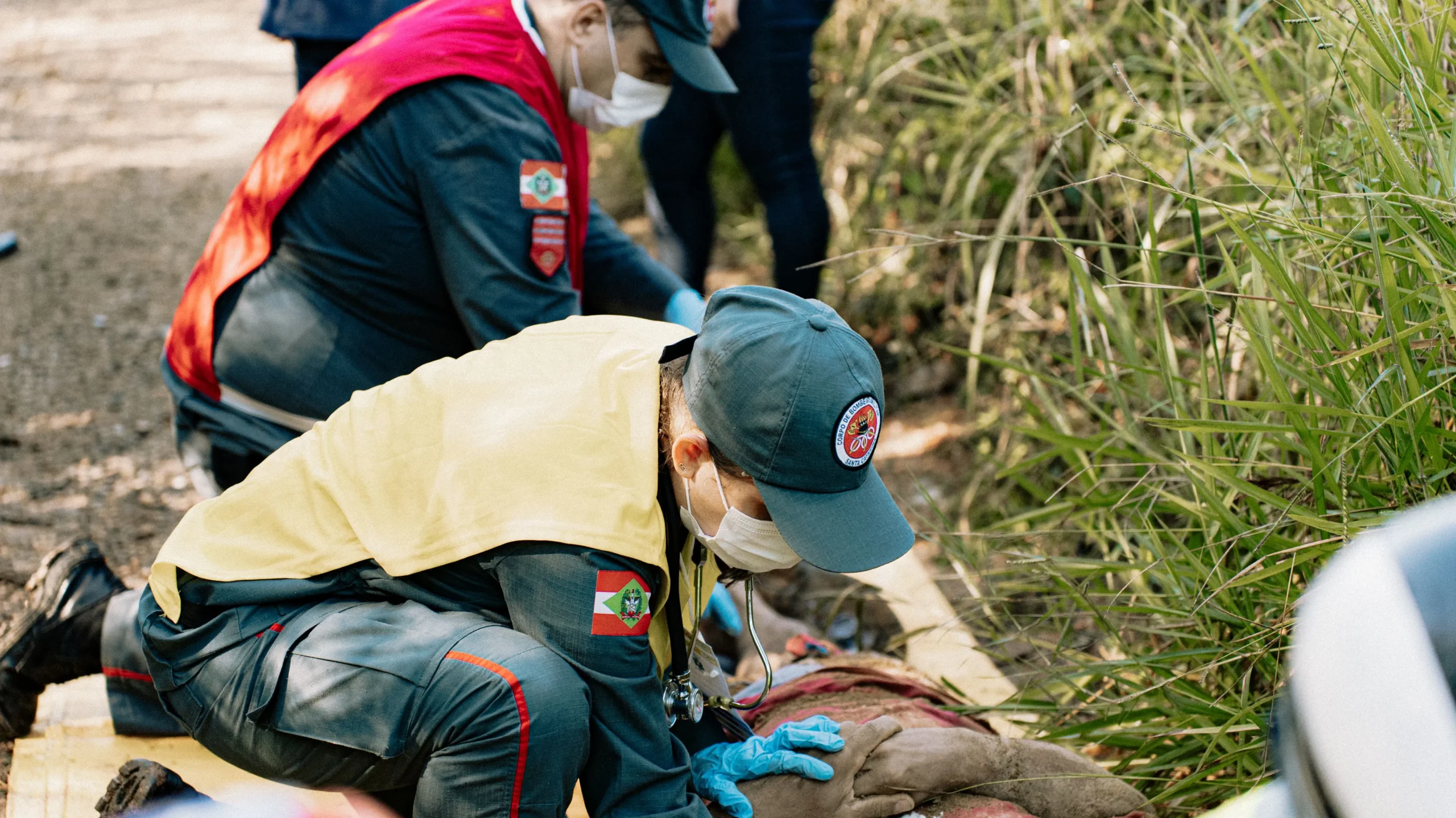First responders treating someone in a field.